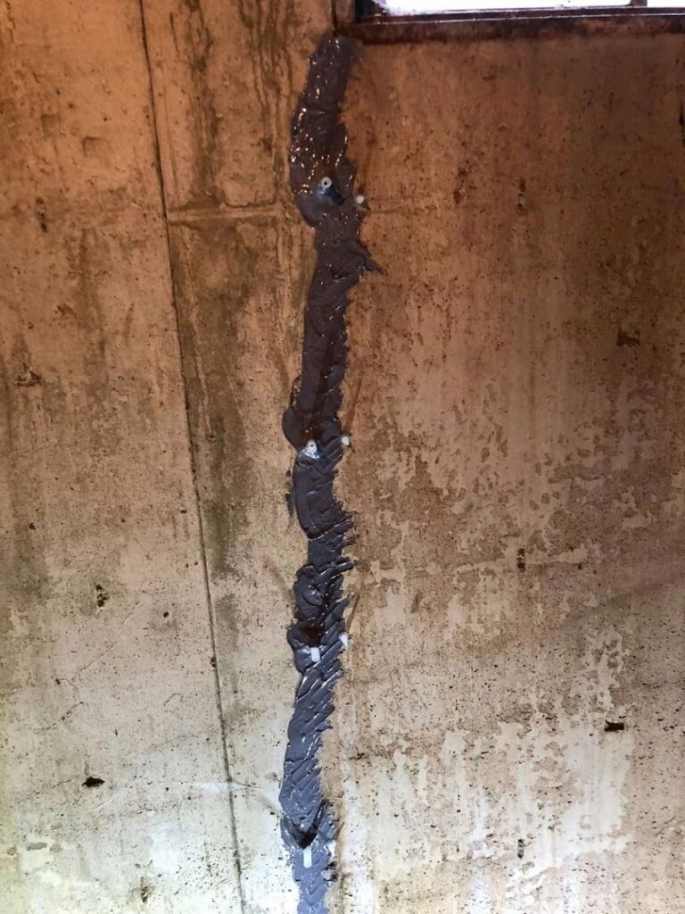 A stained and cracked concrete wall, indicating water damage that requires specialist attention from Northeast Wisconsin Waterproofing, LLC in Green Bay, WI.