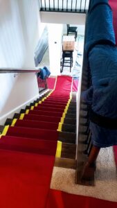 A staircase protected with red runners and moving blankets, prepared by S&P Network's Marathon Moving Solutions in Mechanicsburg, PA.