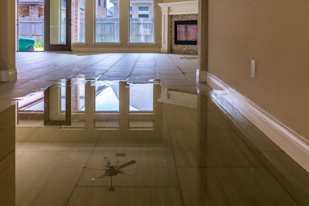 A room with significant standing water on the floor, indicating severe water damage, ready for remediation by 1d Remedy LLC in Mechanicsburg, PA
