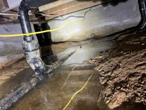 Standing water and pipes visible in a crawl space, indicating significant water damage requiring Certified Restoration in San Diego, CA