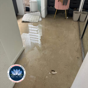 Standing water on a concrete floor in a room, indicating water damage being addressed by Lotus Restoration Services in Gilbert, AZ.