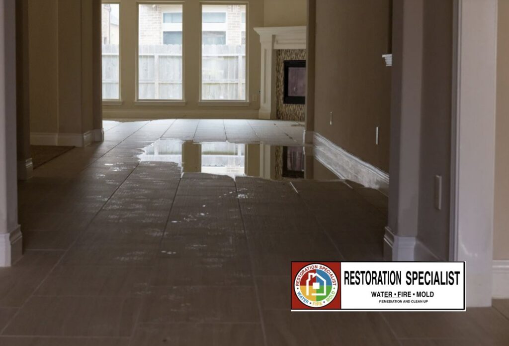 Standing water on a tiled floor in a room after water damage, requiring restoration by Restoration Specialist in O Fallon, MO.