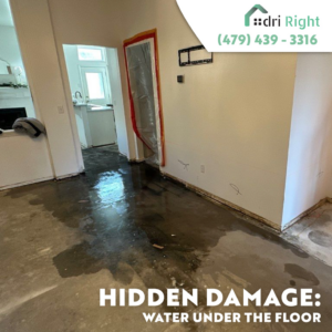 Standing water on a concrete floor with removed baseboards, indicating hidden water damage, by Dri Right Restoration of Arkansas in Springdale, AR.