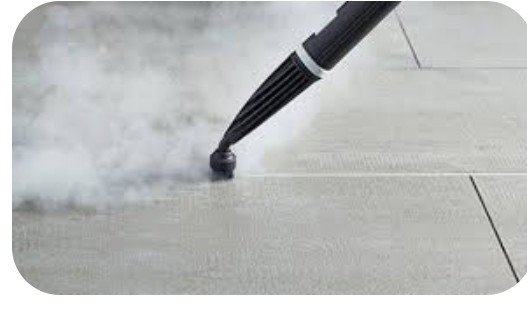 A close-up of a steam cleaner nozzle cleaning a tiled floor, emitting steam, by D A E S Cleaning LLC in Billings, MT.