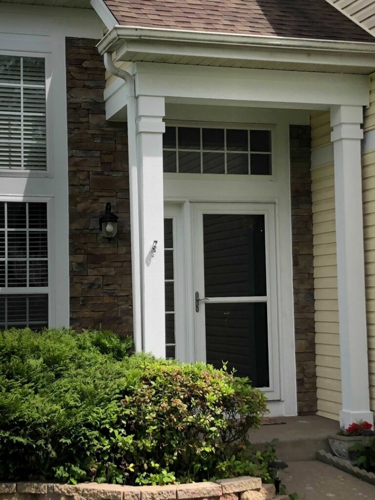A close-up view of stone veneer paired with light yellow siding, completed by A&D Exteriors in Naperville, IL.