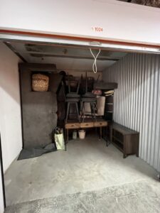 A storage unit filled with furniture and boxes, representing storage services offered by Prime Moving Boston, MA.
