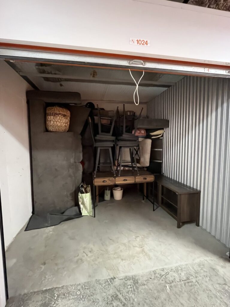 A storage unit filled with furniture and boxes, representing storage services offered by Prime Moving Boston, MA.