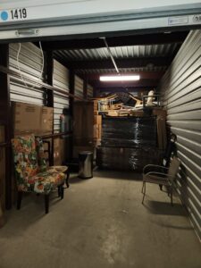 A storage unit packed with various household items and furniture, handled by Ang Moving Co in Dallas, TX