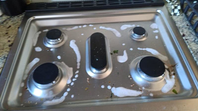A stovetop with cleaning solution applied, ready for scrubbing by Dirt Busters Cleaning Company in Peoria, AZ.