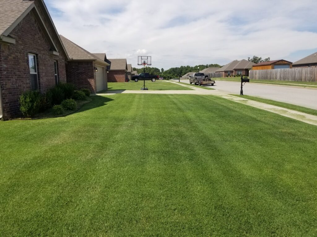 A vibrant green lawn with perfect mowing stripes, a signature of Full Throttle landscapes and lawn care in Port Orchard, WA.