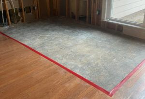 Stripped subfloor with red tape, indicating an area undergoing water damage remediation by 1st Response Emergency Repairs, LLC in Scott, LA.