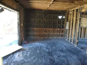 Stripped interior of a fire-damaged building showing exposed studs and charred surfaces, handled by Building Assisting Group Demolition INC in Tacoma, WA.