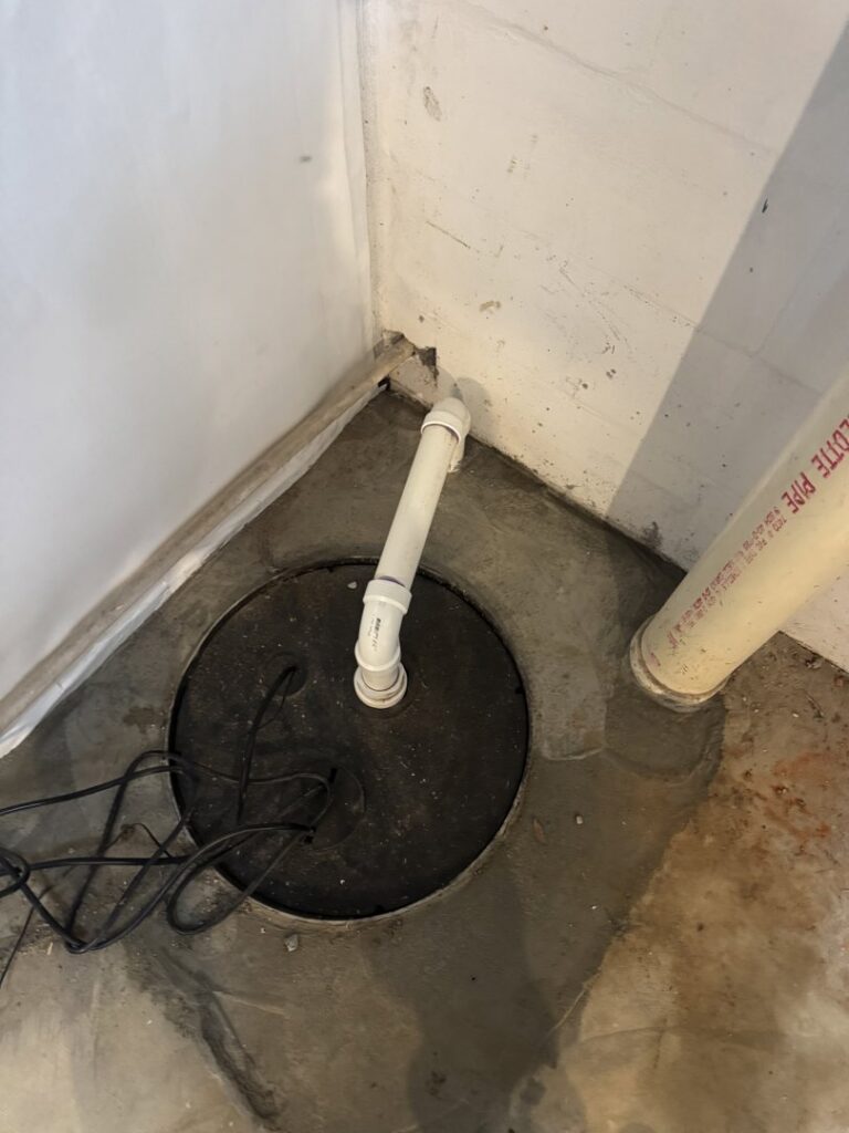 A sump pump installed in a concrete floor for water removal by Wetlock Waterproofing in Rock Hill, SC.