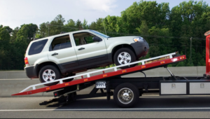 A white SUV being loaded onto a red flatbed tow truck by Alexandria VA Towing in Alexandria, VA.