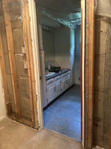 A hand holding a tablet showing an augmented reality assessment for water damage planning by Flood Force in Dayton, OH.