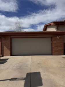 A tan paneled residential garage door installed by Cowboy State Garage Doors, LLC in Cheyenne, WY.