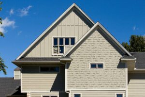 A house featuring tan horizontal siding and decorative shingle siding on the gable by HP Exteriors in Woodstock, GA