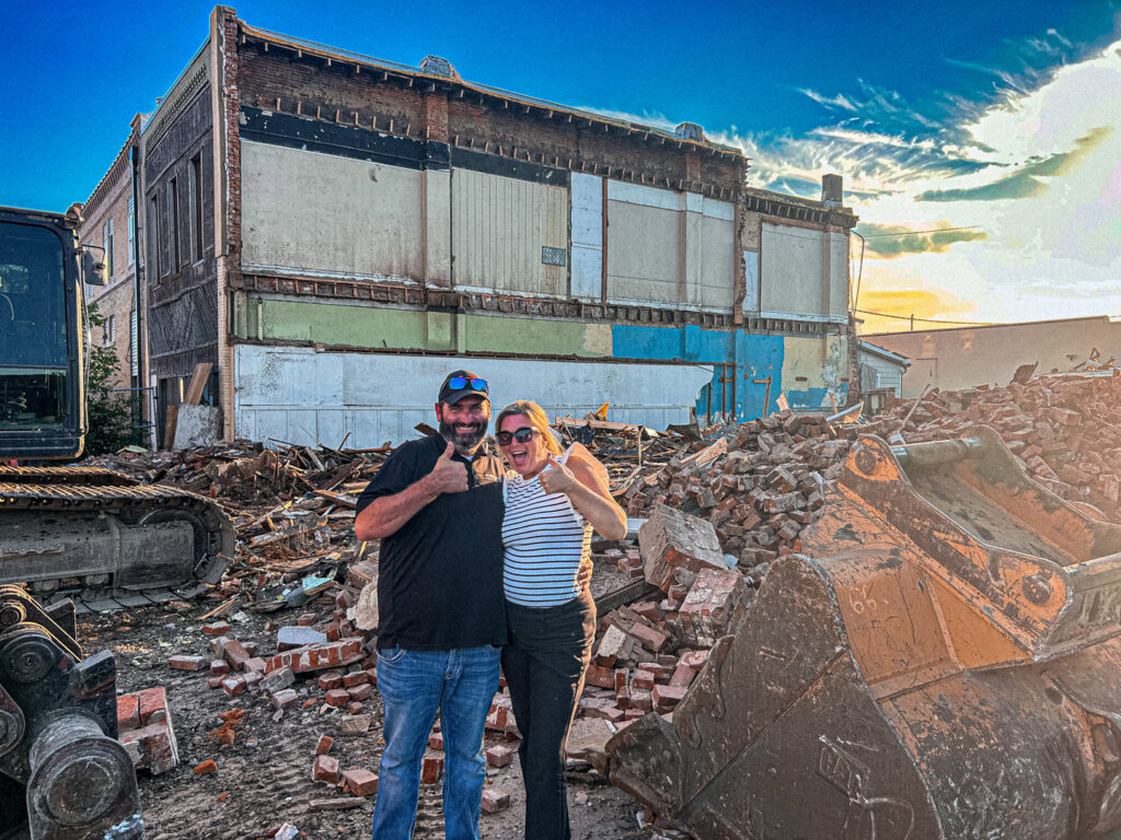 Two team members from DeCarlo Demolition Company giving thumbs up at a completed demolition site in Des Moines, IA.