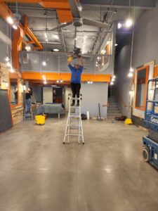 A team of house cleaners deep cleaning a commercial space, including a ceiling fan, by Arizona Housekeeping Service in Phoenix, AZ.