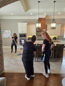 A cleaning team mopping a kitchen floor in a home cleaned by Platt Cleaning Services in Lafayette, LA.