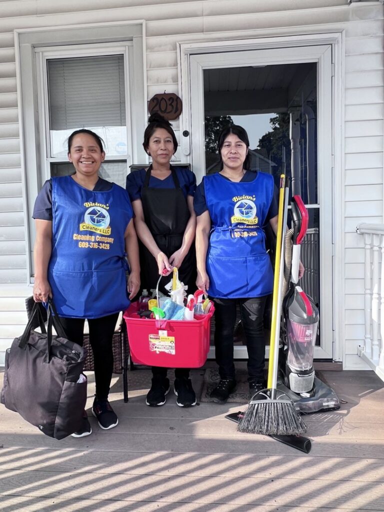 A team of professional house cleaners from Bivian's Cleaners LLC standing with their supplies in Trenton, NJ.