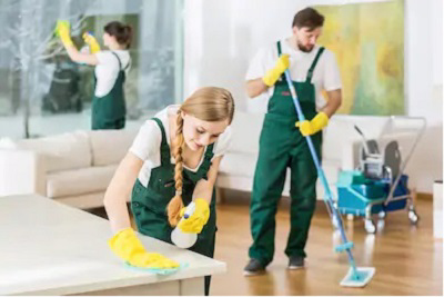 A team of house cleaners from Apple Cleaning performing various cleaning tasks in a home in Anniston, AL.