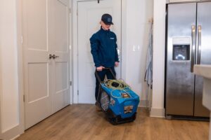 A RestoPros technician bringing professional drying equipment into a home for water damage restoration in Lancaster, PA.