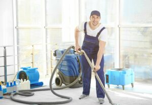 A water damage technician cleaning a carpet with a professional extractor and air movers at Water Damage Pro in Minneapolis, MN