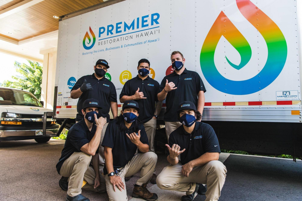 A technician cleaning an LGR 7000 dehumidifier next to a company van for Premier Restoration Hawaii in Honolulu, HI.