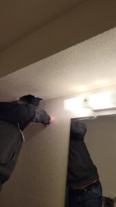A technician cutting into a wall or ceiling for water damage inspection or remediation by Robinson Restoration in Vancouver, WA