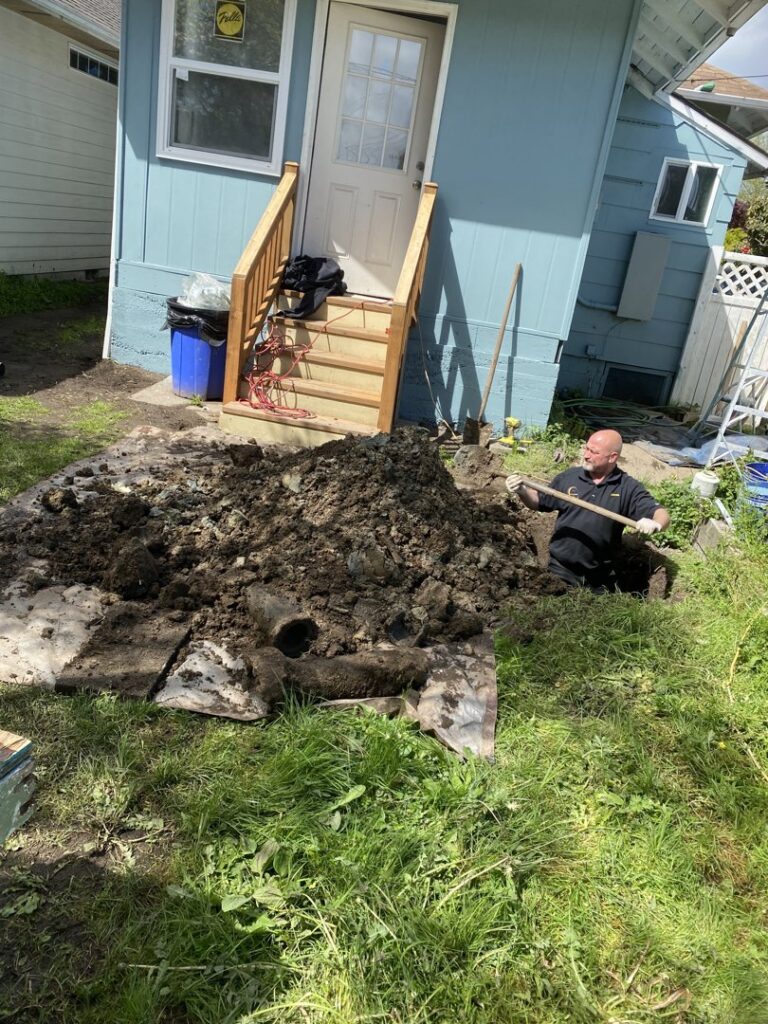 A DNA Drain Cleaning & Sewer technician digging a trench for underground pipe repair in Tulalip, WA.