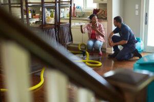 A ServiceMaster technician discusses water damage with a homeowner, with drying equipment visible in Aberdeen, SD.