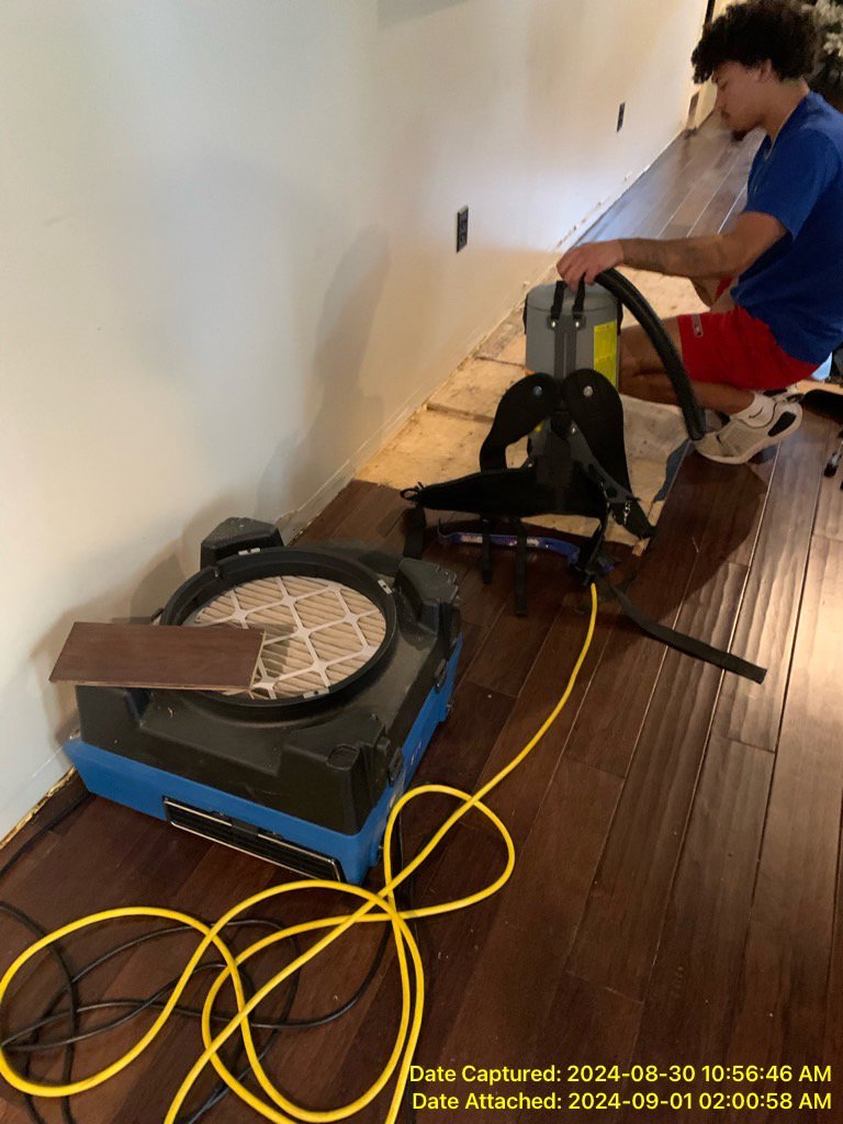 A technician using specialized equipment to dry a hardwood floor affected by water damage for Prime Restoration in Lancaster, PA.