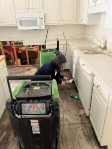 A SERVPRO technician using drying equipment to restore a kitchen after water damage in Owensboro, KY.