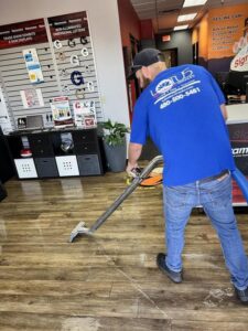 A technician from Lotus Restoration Services extracting water from a wooden floor in Gilbert, AZ, during a water damage cleanup.
