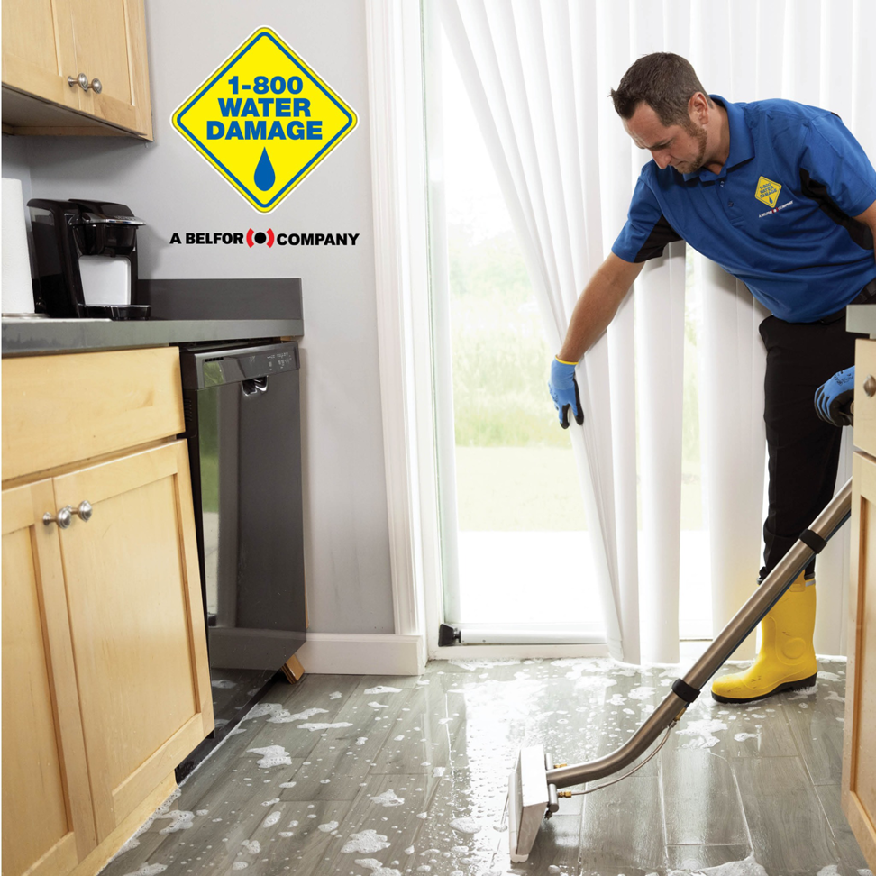 A technician from 1-800 Water Damage of Rogers and Bentonville extracting water from a kitchen floor in Fort Smith, AR.