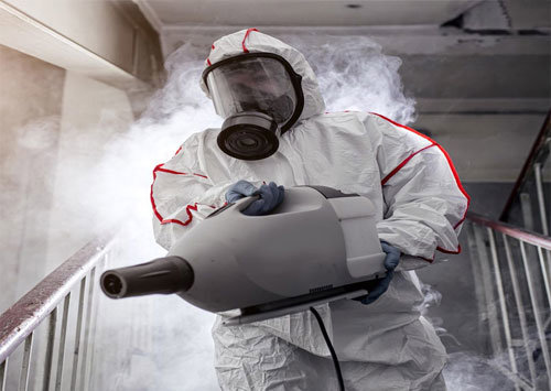 A technician in a hazmat suit performing fogging for disinfection or mold remediation after water damage by PROTECH Restoration & Cleaning in Philadelphia, PA.