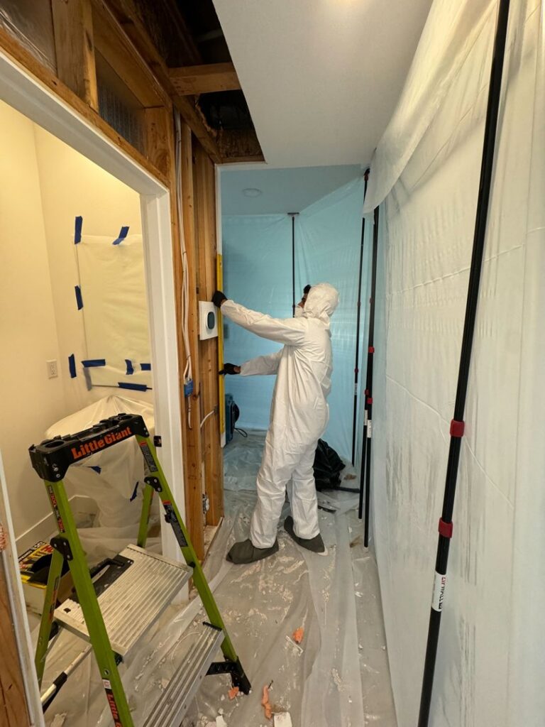 A technician in a hazmat suit working within a containment area for remediation by Verg Restoration in Vancouver, WA