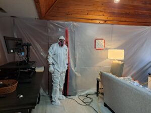 A technician in a hazmat suit working inside a contained area for mold or water damage remediation by AdvantaClean of Cabarrus and Rowan Counties in Concord, NC.