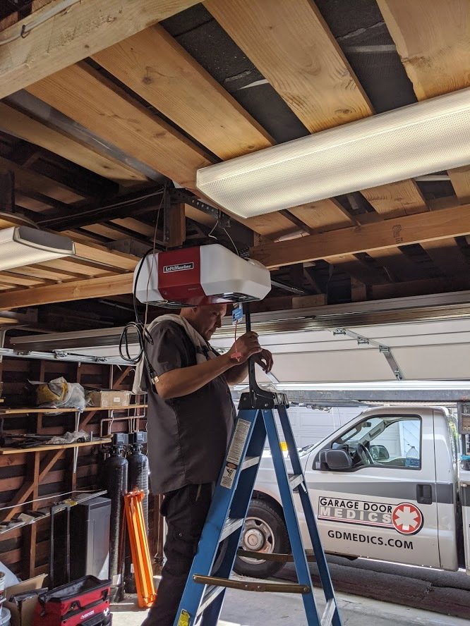 A Garage Door Medics technician installing or repairing a garage door opener in Boise, ID.
