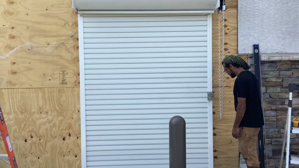 A technician installing a roll-up security door for Delaware Express Garage Door Service in Wilmington, DE