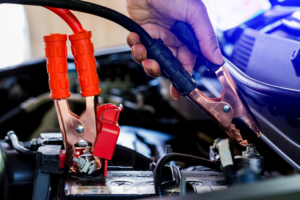 A technician jump-starting a car battery, a service offered by Buckeye Riverside Towing in Cincinnati, OH.