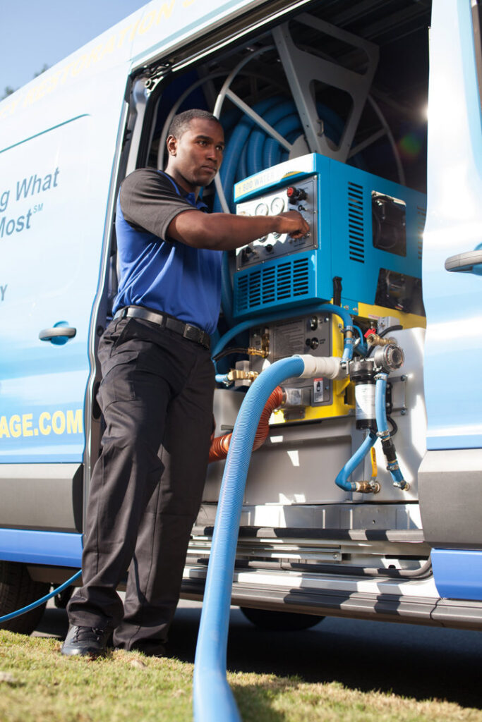 A technician from 1-800 Water Damage of Harrisburg, PA operating truck-mounted water extraction equipment in York, PA.