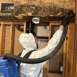 A technician in a hazmat suit performing remediation work on water-damaged and possibly moldy structural elements for Rainbow International of Coeur D'alene in Post Falls, ID
