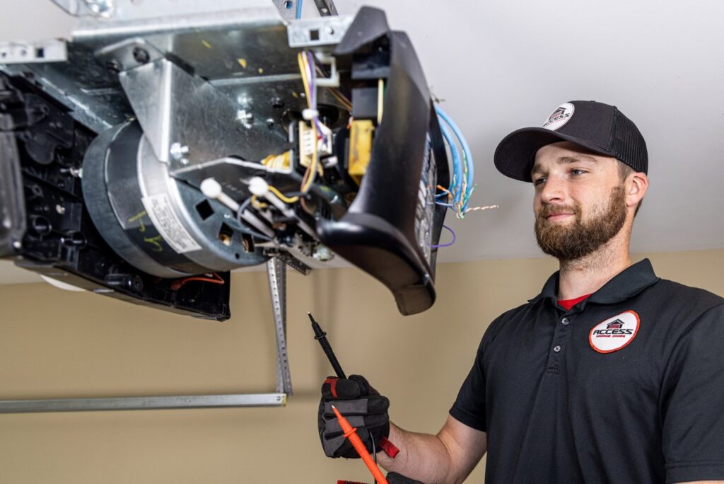 A technician from Access Garage Doors of Treasure Valley repairing a garage door opener with a multimeter in Meridian, ID.