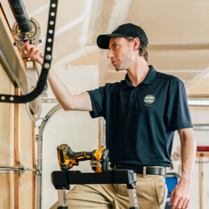 A Precision Garage Door Service of NC technician repairing a garage door opener mechanism in Morrisville, NC.