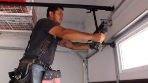 A technician repairing a garage door opener mechanism for Valley Overhead Door in Las Vegas, NV.