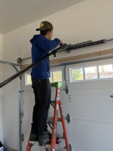 A technician repairing garage door torsion springs for Delaware Express Garage Door Service in Wilmington, DE