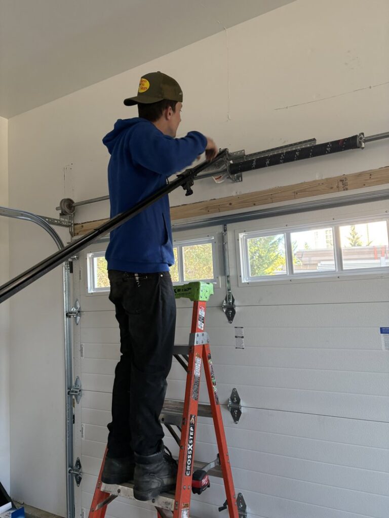 A technician repairing garage door torsion springs for Delaware Express Garage Door Service in Wilmington, DE