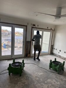 Technician spraying a room with air movers for water damage remediation. Paul Davis Restoration, Belmont, MA.